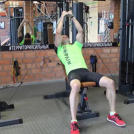 Сведения рук на нижнем блоке лежа на наклонной скамье