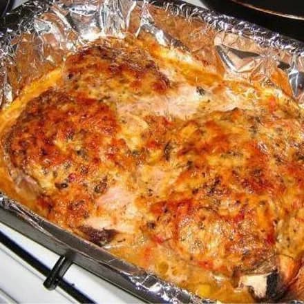 Spicy pork with cheese and mushrooms in the oven